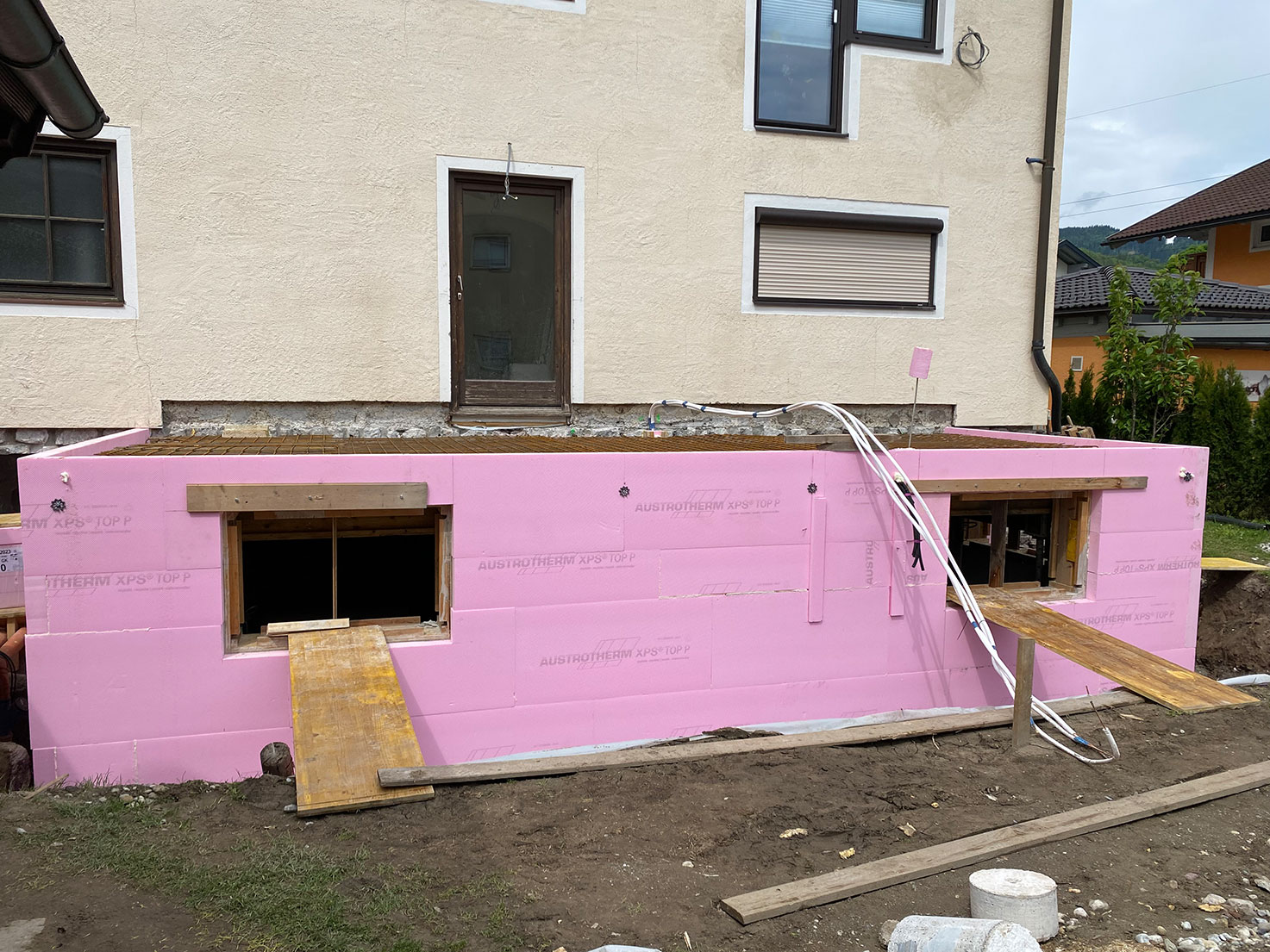Fertiggestellte Kellerwände mit pinker Austrotherm XPS-Dämmung – Projekt Krappinger, Golling, Robert Präauer.