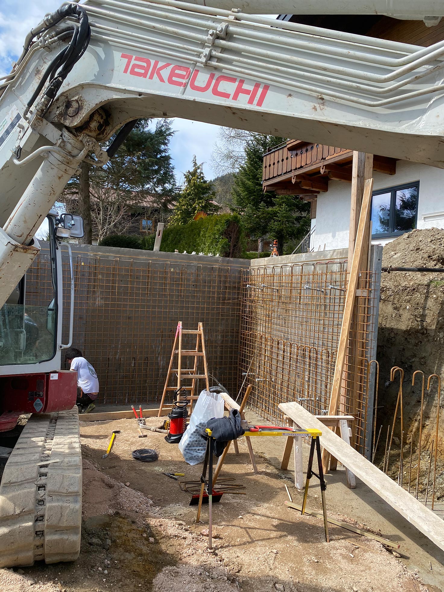 Baustelle in Flachau während der Errichtung einer Stützmauer für ein Carport mit vier Stellplätzen – Bewehrung und Schalung in Vorbereitung, Robert Präauer / Praebau.