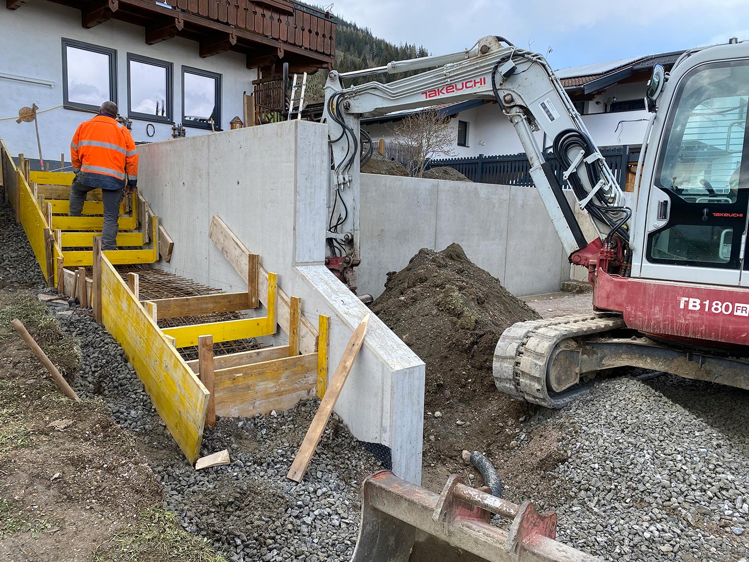 Bauarbeiten an der Sichtbeton-Stützmauer für das Carport mit vier Stellplätzen in Flachau – Schalung und Aushub im Einsatz, Robert Präauer / Praebau.